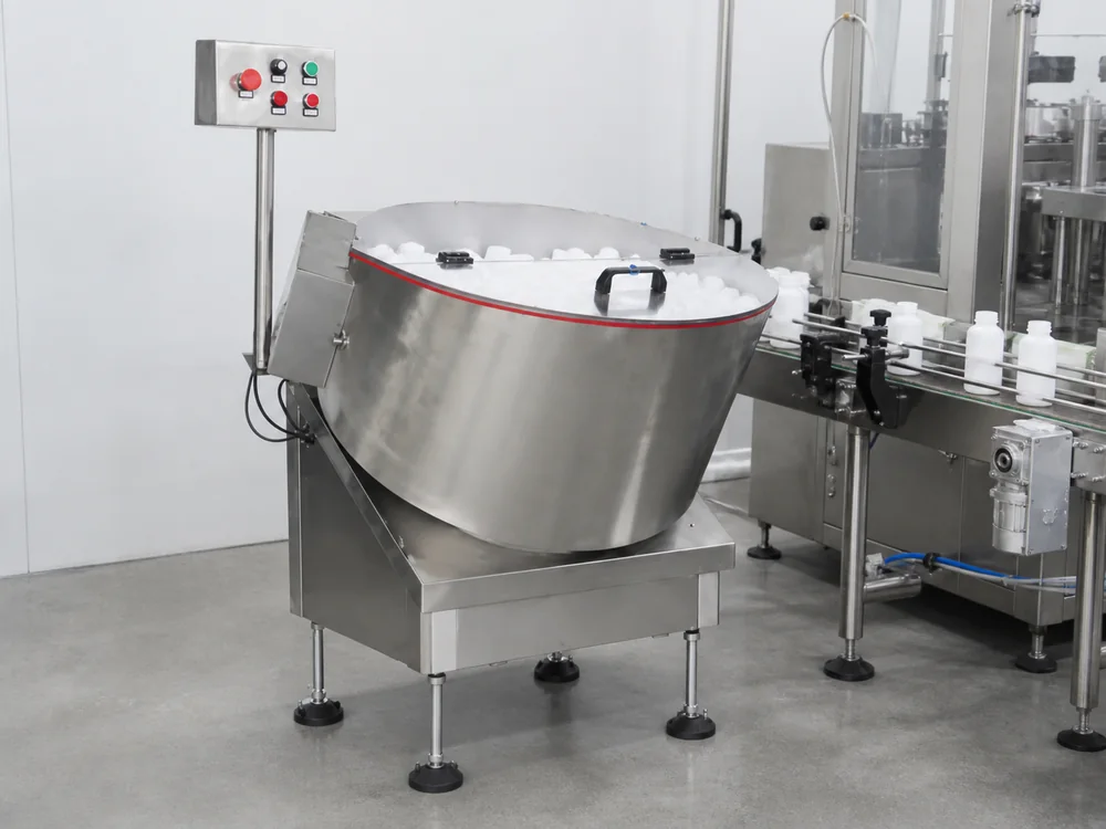 Automatic bottle unscrambler orienting containers onto a production conveyor